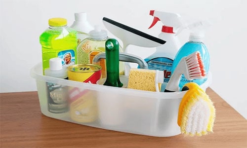 Plastic container full of cleaning supplies, brushes and sponges